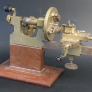 19th century brass and steel watchmaker lathe on wooden basement.