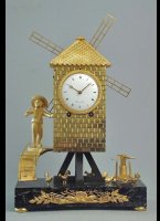 Case: bronze, firegilt, rectangular marble base, 4 bun feet, on the front gilt applied oak leaves and a flail, on top the windmill on wooden beams, on the left side a staircase leading to a door with the miller in front with a handling winch and some chickens. Dial: enamel, radial Roman numerals, pierced, gilt hands. Movm.: brass full plate movement, gilt, 2 barrels for going and striking train, keywind, 1 hammer / 1 bell, on reverse side applied train for constant drive of the windmill's airfoil by going train, 10-day duration